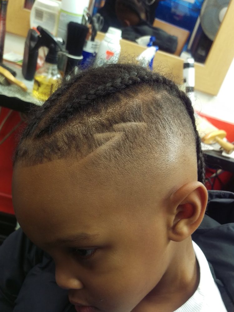 Kids braided style with shaved design at Otis Barbers